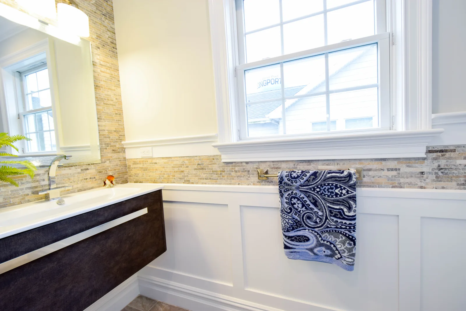Bathroom with a dark floating vanity and white wainscoting