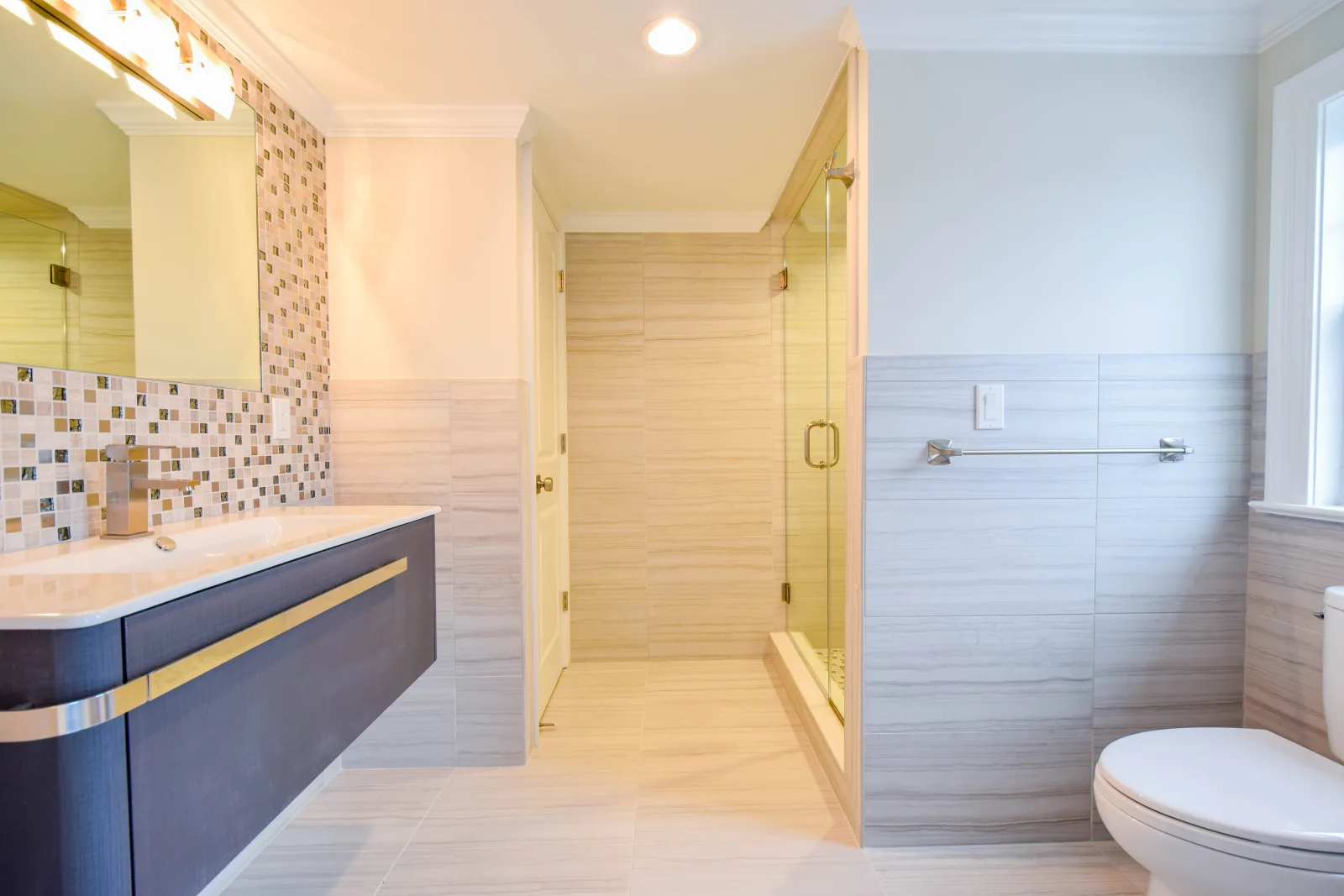 Bathroom with a navy vanity and a frameless glass shower