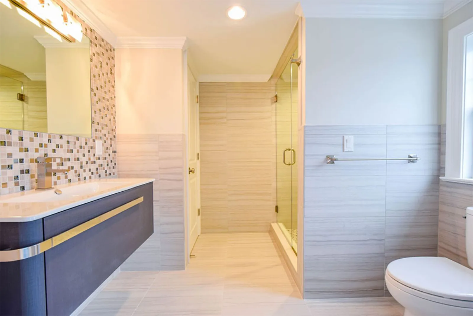 Navy vanity beside a mosaic tiled shower