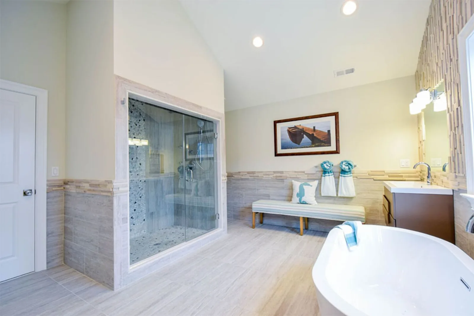 Bathroom with a soaking tub, glass shower and window bench