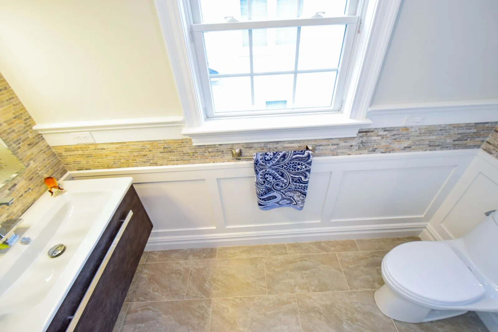 Built in tub under a window with wainscoted walls