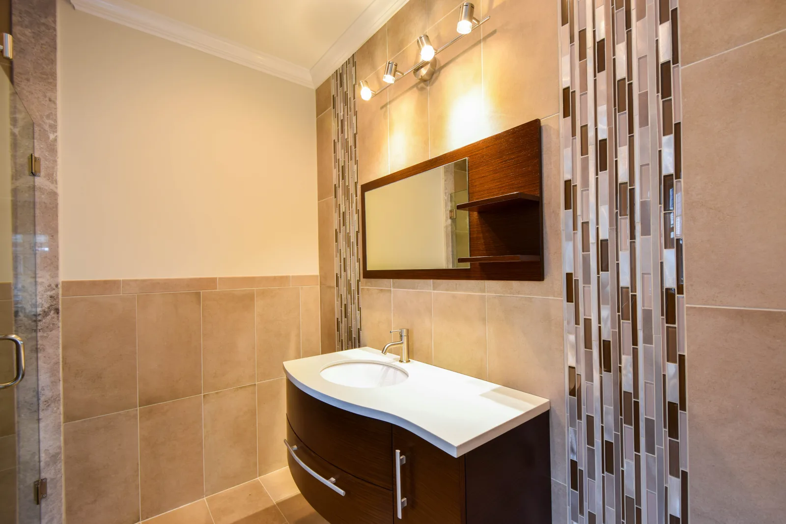 Vanity with a vertical tile accent wall and framed mirror