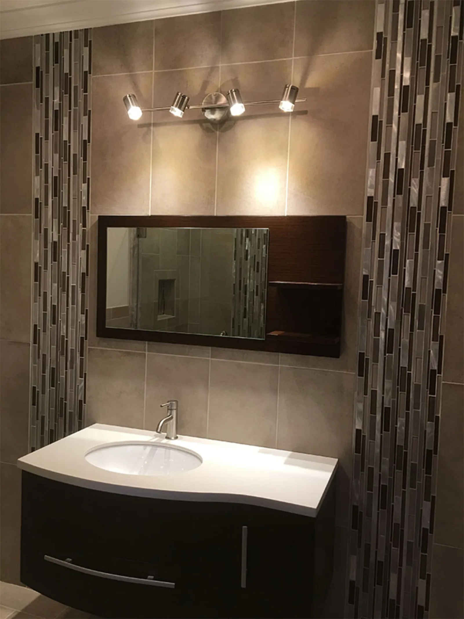 Vanity wall with vertical mosaic tile and sconce lighting