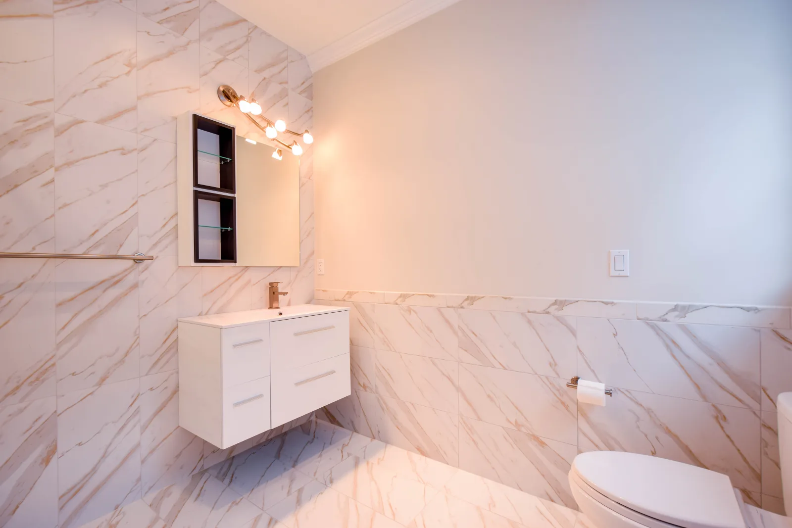 White floating vanity against marble look walls