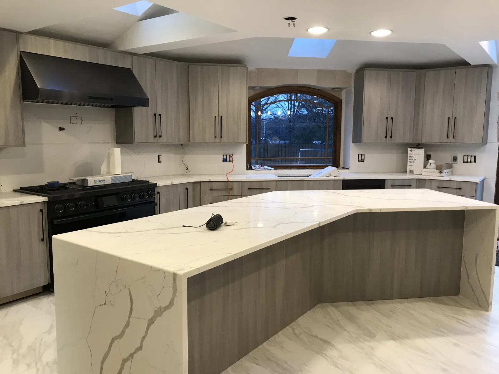 Kitchen with an angled island under a skylight