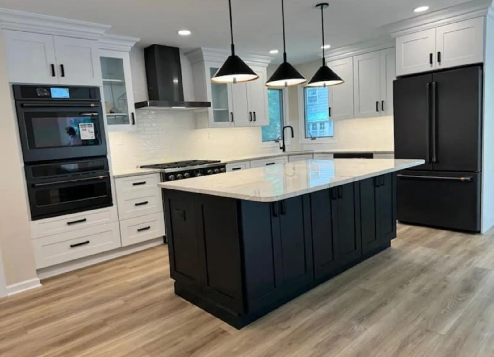 White kitchen with a black island and black appliances