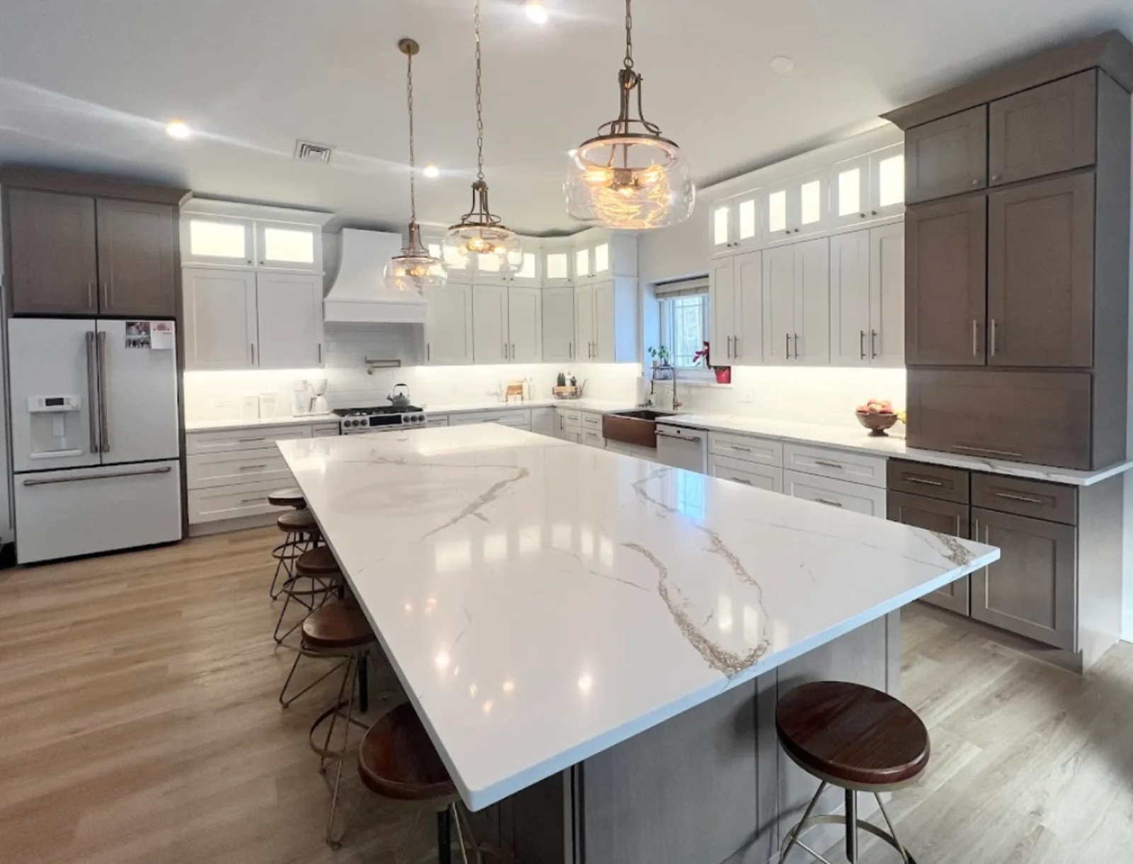 Grey kitchen with a large island and dome pendant lights