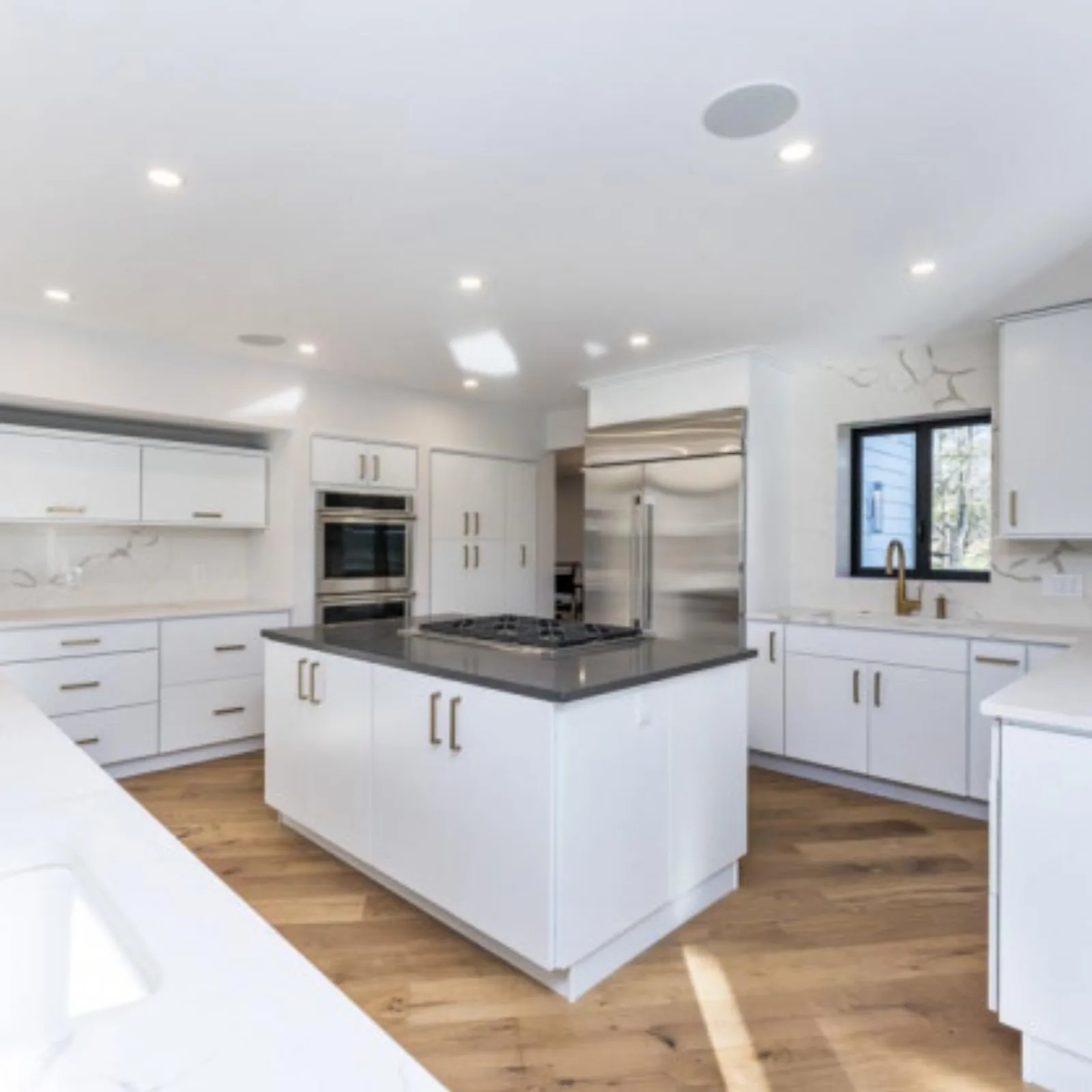 White kitchen with an island and a double wall oven