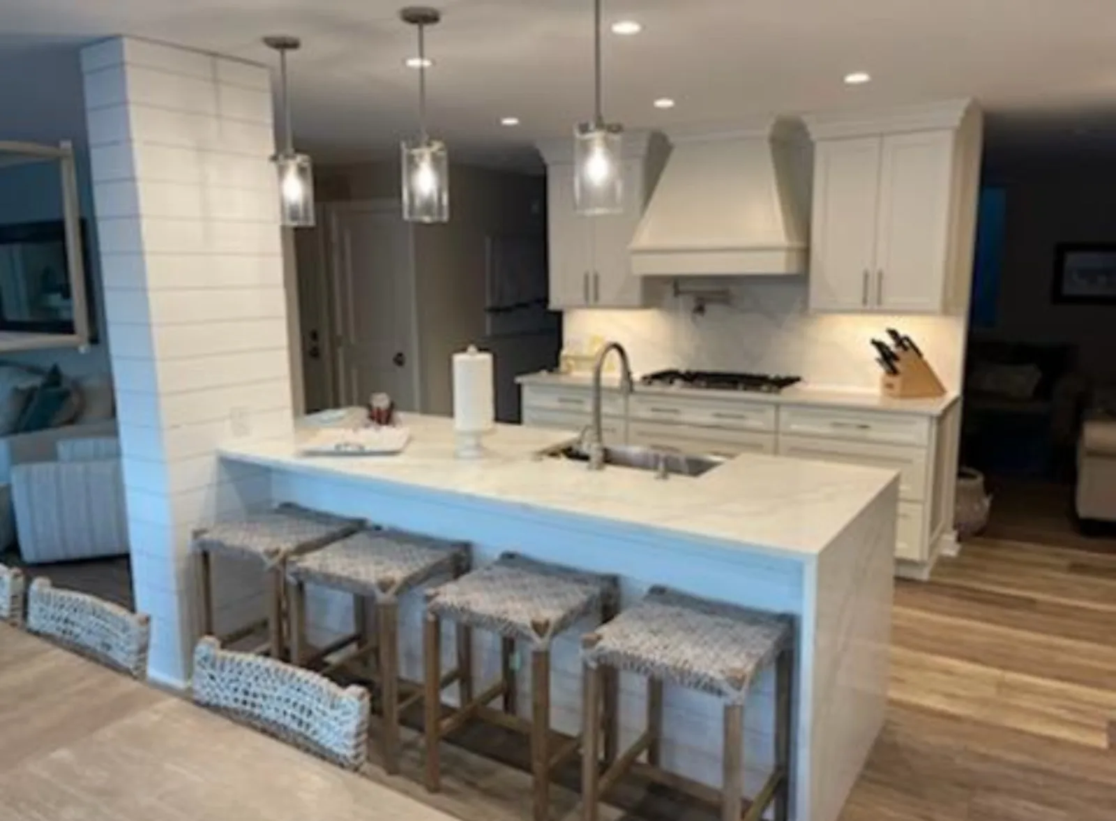White kitchen island with a shiplap hood wall