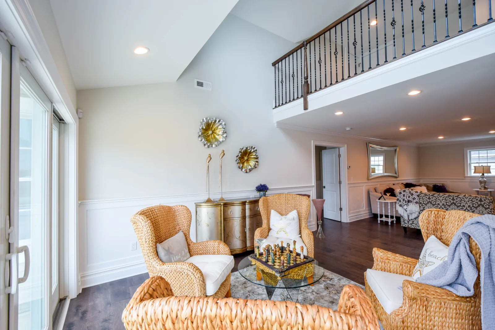 Open living area with a loft railing above and arched windows