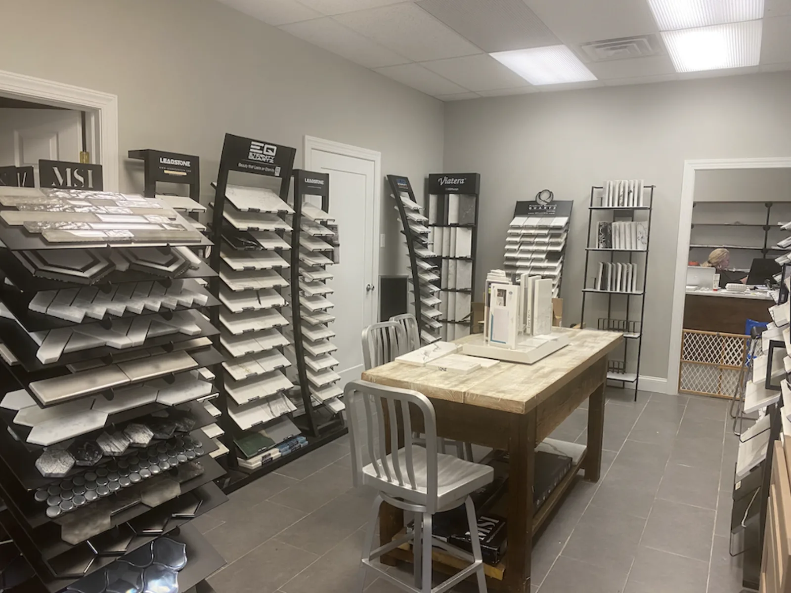 Showroom racks of cabinet door samples around a work table